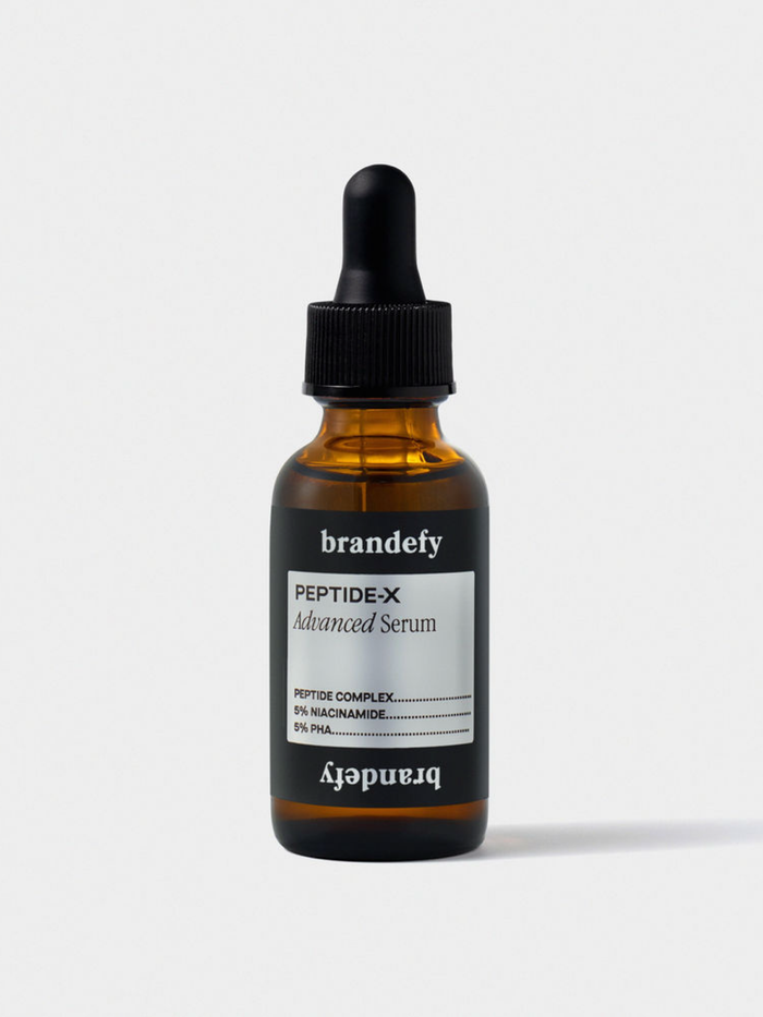 The Peptide-X Advanced Serum in an amber glass dropper bottle with a black cap, on a light grey ground.