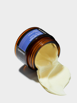 Dual Retinol Renew Cream: an amber glass jar on its side with pale cream spilling from it.