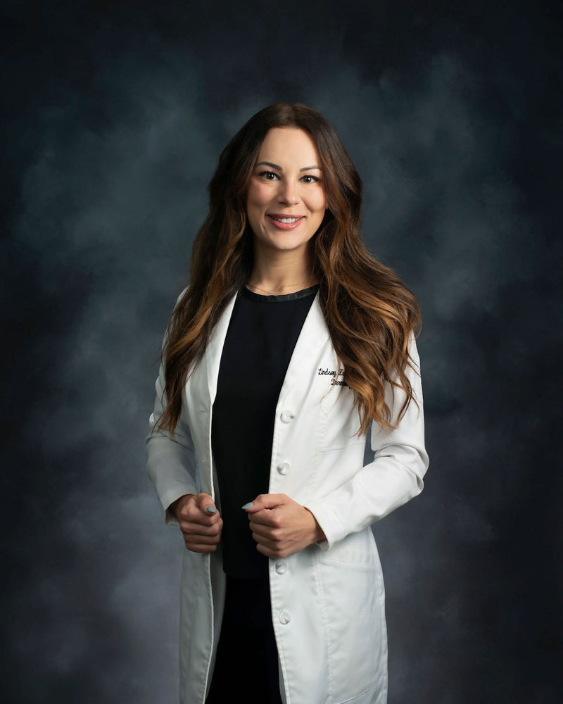 Dr. Lindsey Zubritsky, board-certified dermatologist and Brandefy partner, in a white lab coat.